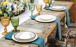 mesa de noivado de madeira com guardanapos azuis e copos coloridos