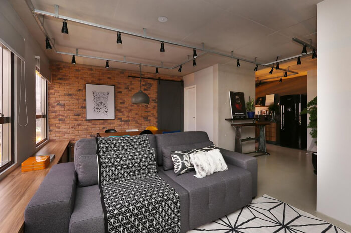imagem de uma sala moderna e compacta com sofá cinza escuro