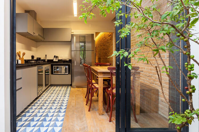 imagem de uma cozinha cinza moderna com uma parede de tijolo à vista