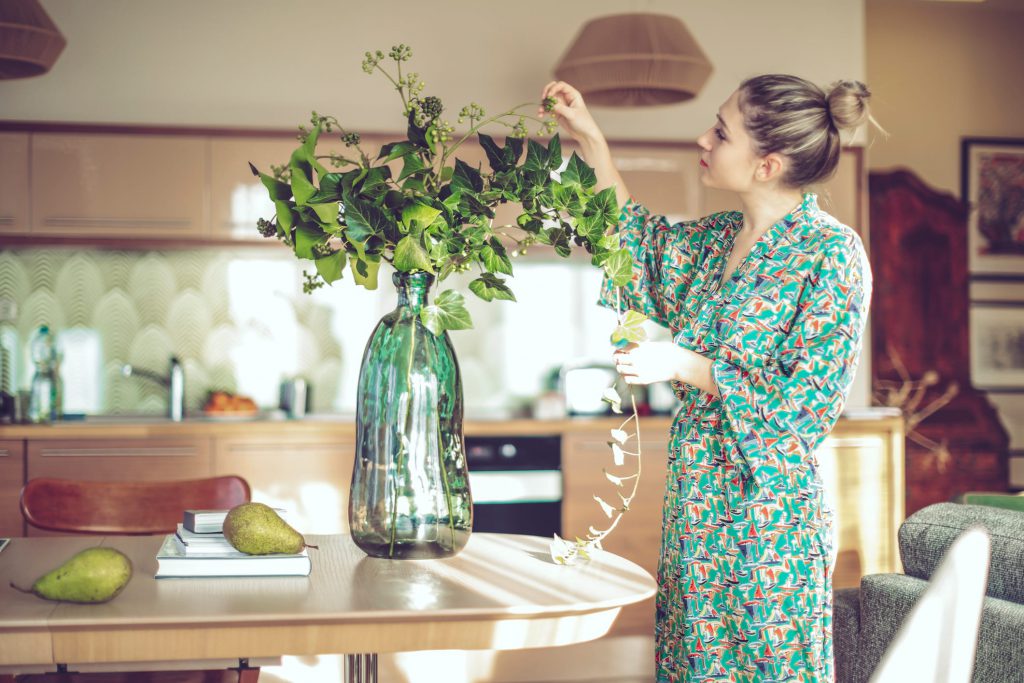 mulher arrumando vaso de plantas