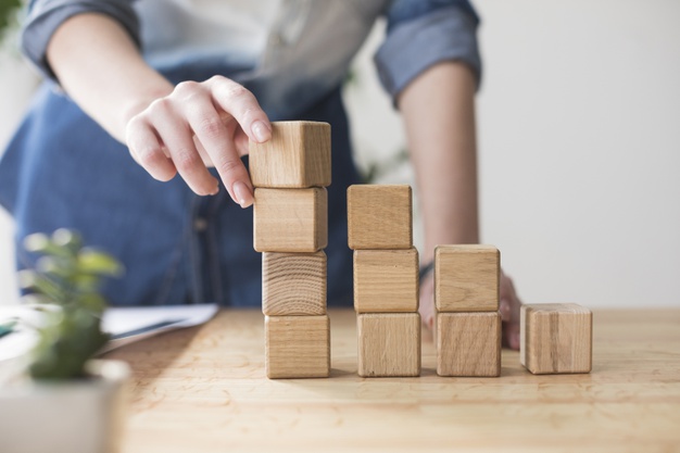 Pessoa empilhando blocos de madeira 