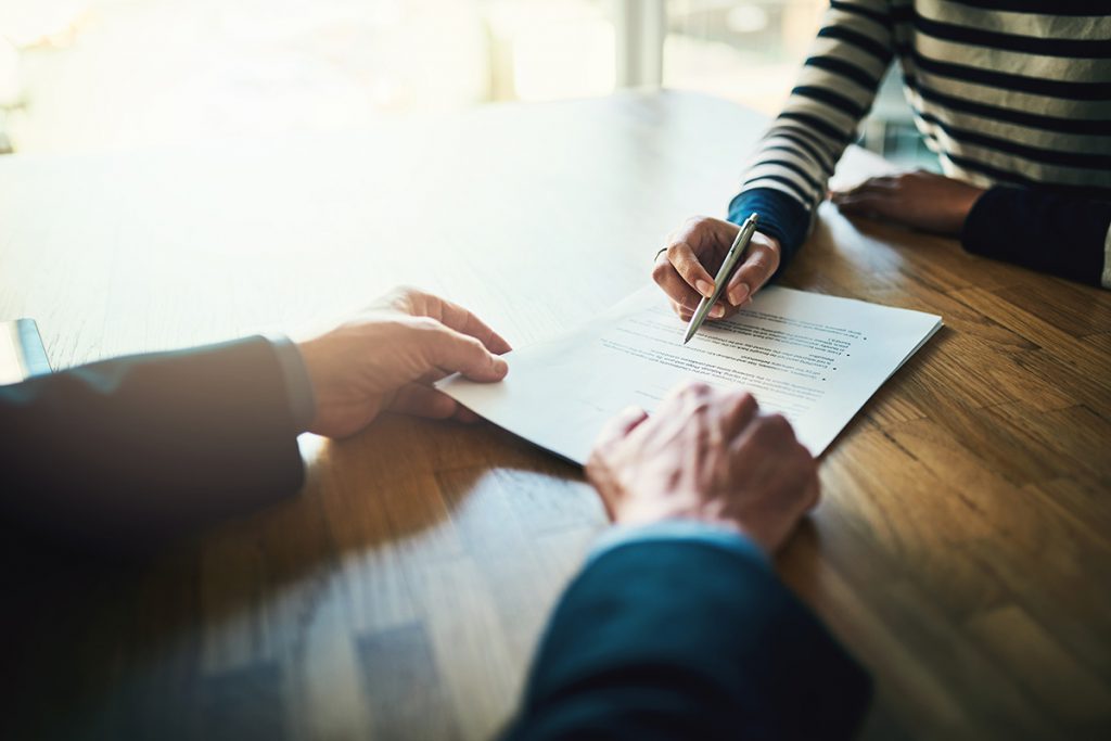 Imagem mostra mulher assinando documentos 