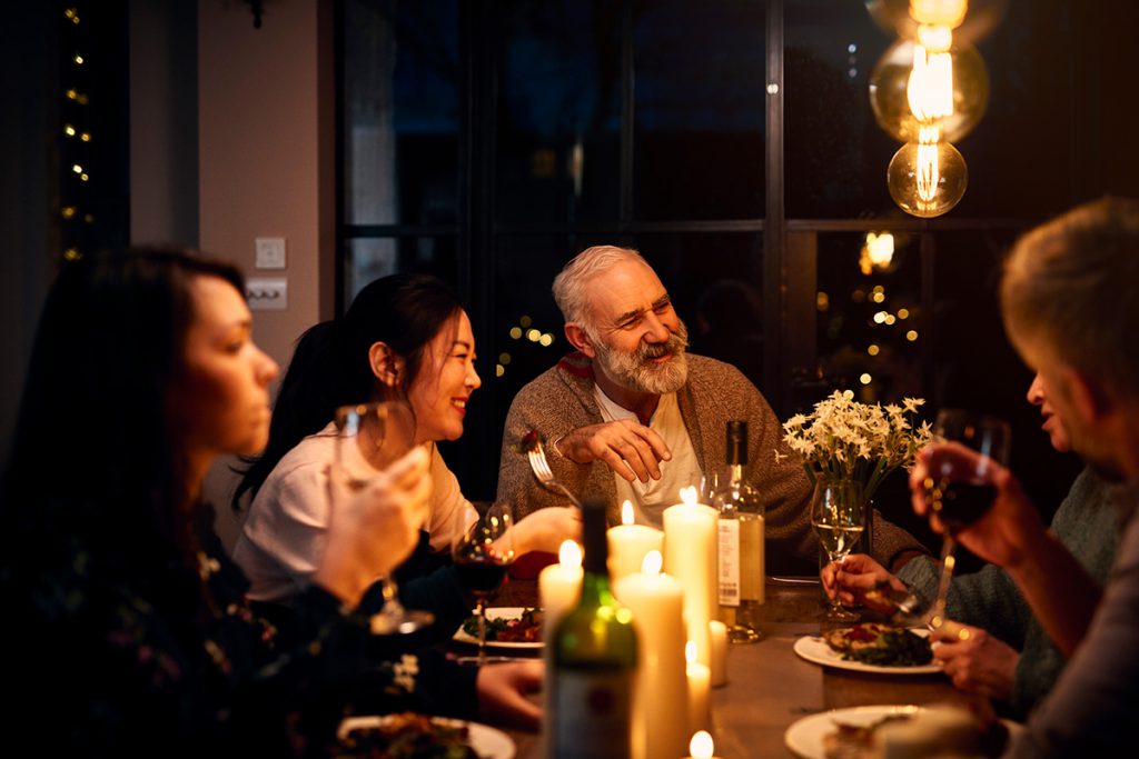 Imagem mostra pessoas sorrindo e jantando